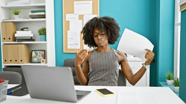 非洲裔美国女商人在办公室里使用笔记本电脑 用文件作为手扇 — 图库照片