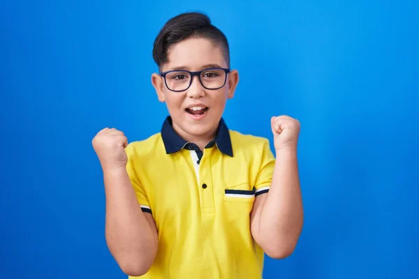 Joven Niño Hispano Pie Sobre Fondo Azul Gritando Orgulloso Celebrando —  Fotos de Stock