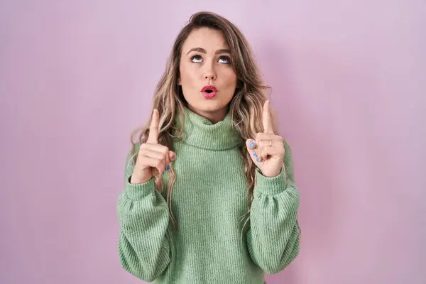 Young Caucasian Woman Standing Pink Background Amazed Surprised Looking Pointing —  Fotos de Stock
