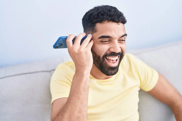 Young Arab Man Listening Voice Message Smartphone Sitting Sofa Home — 스톡 사진