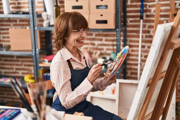 Middle age woman artist smiling confident drawing at art studio