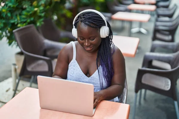 Kahve Dükkanının Terasında Dizüstü Bilgisayar Kulaklık Kullanan Afrikalı Amerikalı Kadın — Stok fotoğraf