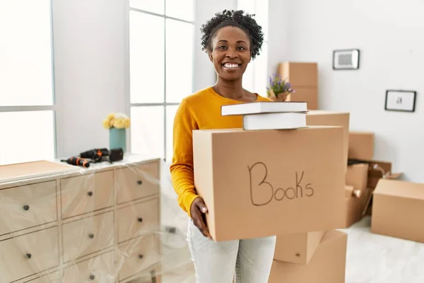 African American Woman Smiling Confident Holding Books Package New Home — Stock Photo, Image