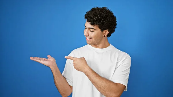 Young Latin Man Smiling Pointing Side Presenting Isolated Blue Background — Stock Photo, Image