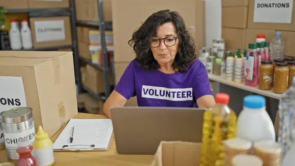Orta Yaşlı Spanyol Kadın Gönüllü Olarak Yardım Merkezinde Laptopunu Kullanıyor — Stok fotoğraf