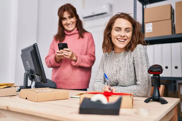 Two Women Ecommerce Business Workers Writing Notebook Using Smartphone Office — Stock Photo, Image