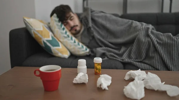 Young Hispanic Man Lying Sofa Sick Tissues Pills Table Home — Stock Photo, Image