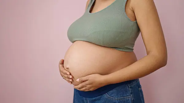 Mladá Těhotná Žena Dotýká Břicho Přes Izolované Růžové Pozadí — Stock fotografie