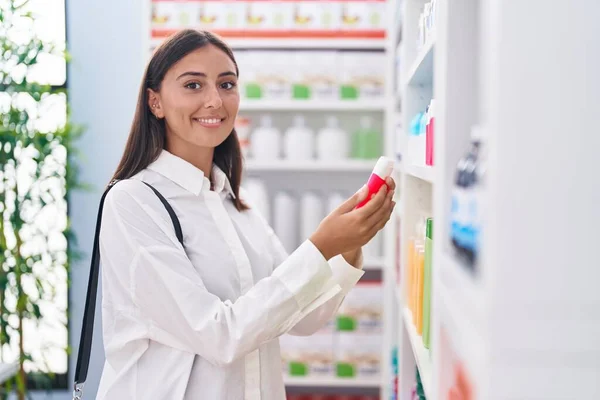 Young Beautiful Hispanic Woman Client Holding Toothpaste Pharmacy — Stockfoto