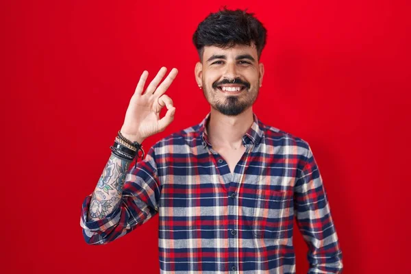 Homem Hispânico Jovem Com Barba Sobre Fundo Vermelho Sorrindo Positivo — Fotografia de Stock