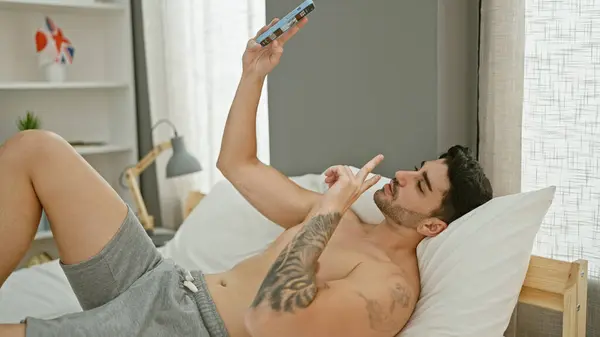 Young Hispanic Man Make Selfie Smartphone Lying Bed Bedroom — 图库照片