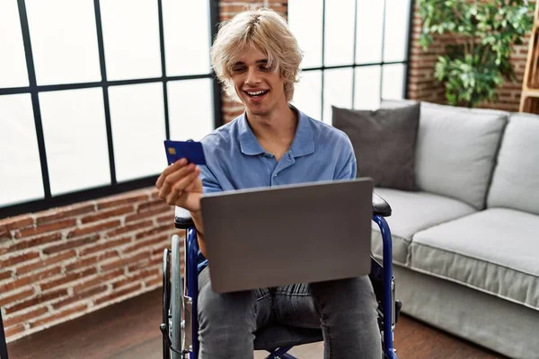 Junger Blonder Mann Sitzt Mit Laptop Und Kreditkarte Rollstuhl Hause — Stockfoto