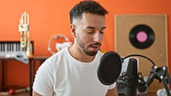 Young arab man musician singing song at music studio