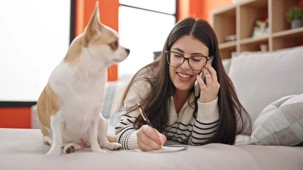 Jonge Spaanse Vrouw Met Chihuahua Hond Aan Telefoon Aantekeningen Liggend — Stockfoto