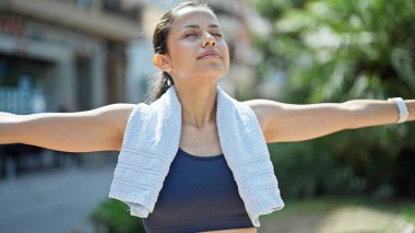 Parkta spor kıyafetleri giyen genç ve güzel bir İspanyol kadın.