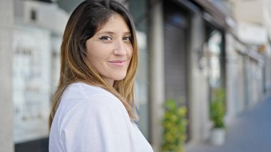 Sokakta kendine güvenen genç sarışın kadın gülümsüyor