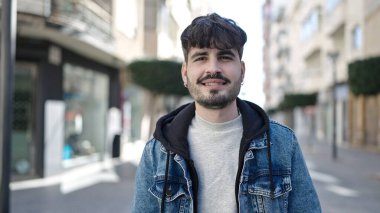Young hispanic man smiling confident at street