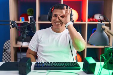 Genç İspanyol adam video oyunları oynuyor. El hareketleriyle gülümsüyor, gözleriyle mutlu yüzlere bakıyor.. 