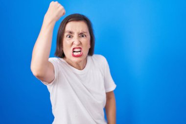 Orta yaşlı Latin bir kadın, öfkeyle bağırırken kızgın ve öfkeli bir şekilde elini kaldırıyor. öfke ve agresif konsept. 