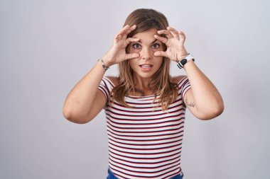 Soyutlanmış arka planda duran genç İspanyol kadın parmaklarıyla gözlerini açmaya çalışıyor, uykulu ve yorgun bir şekilde sabah yorgunluğu çekiyor. 