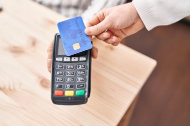 Genç İspanyol adam kredi kartıyla ödeme yapıyor.