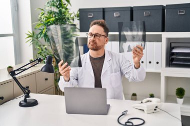 Kafkasyalı genç bir doktor klinikteki masada oturuyor.