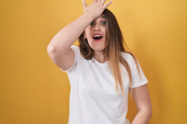 Young Brunette Woman Standing Yellow Background Surprised Hand Head Mistake — Stock Photo, Image