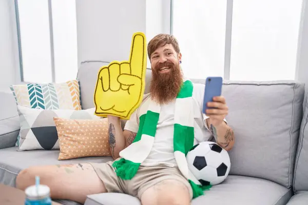 Junger Rotschopf Unterstützt Fußballmannschaft Mit Smartphone Und Hält Große Hand — Stockfoto