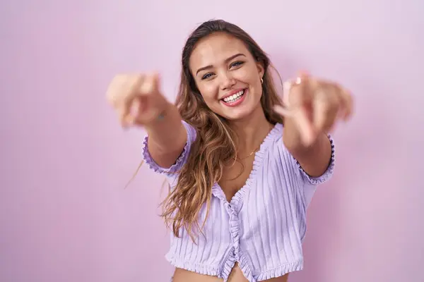 Молодая Латиноамериканка Стоящая Розовом Фоне Указывая Тебя Камеру Пальцами Улыбаясь — стоковое фото