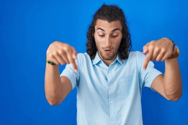 Young Hispanic Man Standing Blue Background Pointing Fingers Showing Advertisement — ストック写真