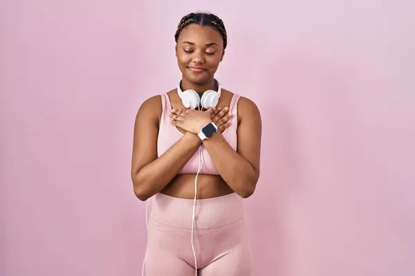 African American Woman Braids Wearing Sportswear Headphones Smiling Hands Chest — Stock Photo, Image