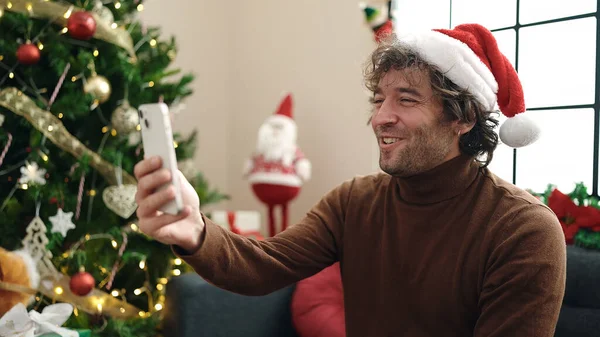 Young Hispanic Man Using Smartphone Sitting Sofa Christmas Tree Home — Stockfoto