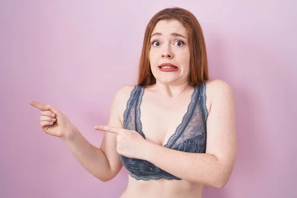 Redhead Woman Wearing Lingerie Pink Background Pointing Aside Worried Nervous — Stock Photo, Image