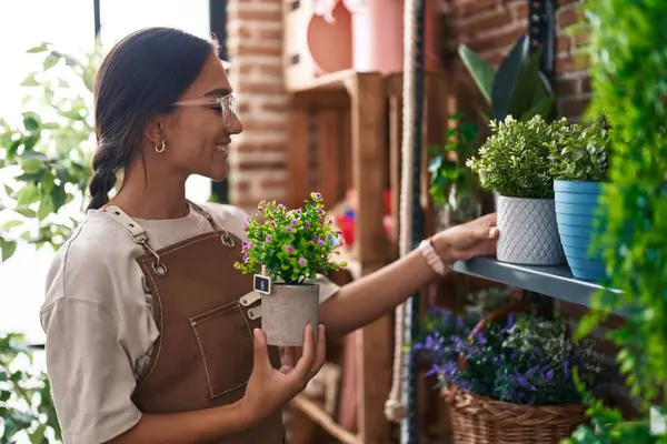 Çiçekçide çiçek tutan güzel İspanyol kadın.