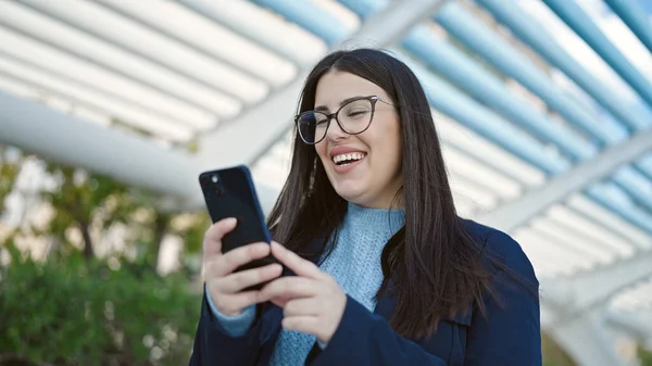 Genç Spanyol Kadın Parkta Akıllı Telefon Kullanarak Gülümsüyor — Stok fotoğraf