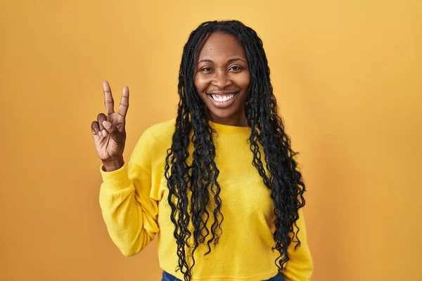Mujer Africana Pie Sobre Fondo Amarillo Sonriendo Mirando Cámara Mostrando — Foto de Stock