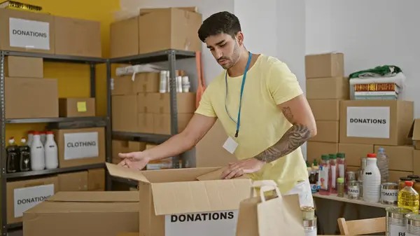 Joven Hispano Voluntario Empacando Donaciones Caja Cartón Centro Caridad — Foto de Stock