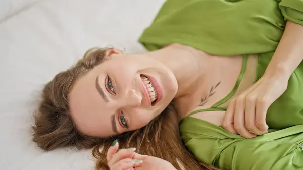 Młoda Blondynka Uśmiecha Się Pewnie Leżąc Łóżku Sypialni — Zdjęcie stockowe