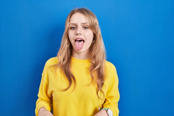 Joven Mujer Caucásica Pie Sobre Fondo Azul Sacando Lengua Feliz —  Fotos de Stock