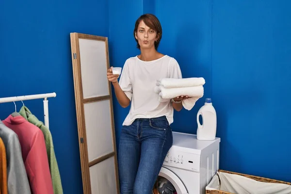 Elinde Temiz Çamaşırları Olan Esmer Bir Kadın Kameraya Bakıp Öpüşürken — Stok fotoğraf