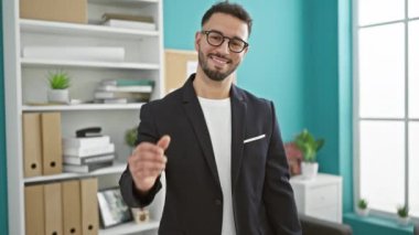 Genç Arap iş adamı ofiste el sıkışırken gülümsüyor.