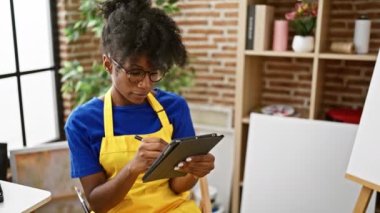 African american woman artist drawing on touchpad at art studio
