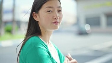 Young chinese woman smiling confident standing at street