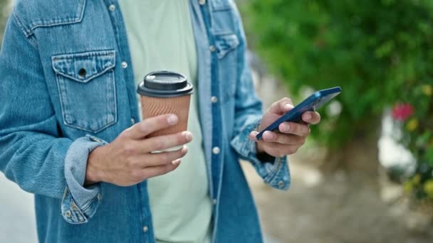 Νεαρός Καυκάσιος Άνδρας Που Χρησιμοποιεί Smartphone Πίνοντας Καφέ Στο Πάρκο — Αρχείο Βίντεο
