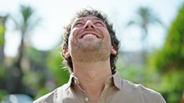 Молодий Іспаномовний Чоловік Посміхається Впевнено Дивлячись Небо Жестом Переможця Парку — стокове відео