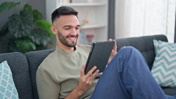 Jonge Spaanse Man Met Touchpad Zittend Bank Thuis — Stockvideo