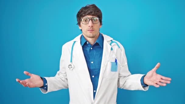 Молодий Іспаномовний Лікар Стоїть Безглуздо Над Ізольованим Синім Тлом — стокове відео