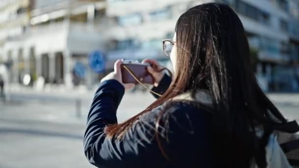 年轻的惊慌失措的女游客背着背包在街上用相机拍照 — 图库视频影像