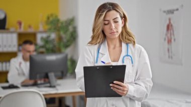 Kadın ve erkek doktorlar klinikte çalışan bilgisayarla tıbbi rapor yazıyorlar.