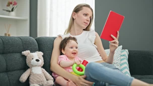 Μητέρα Και Κόρη Διαβάζουν Βιβλίο Ενώ Παίζουν Στεφάνια Στο Σπίτι — Αρχείο Βίντεο